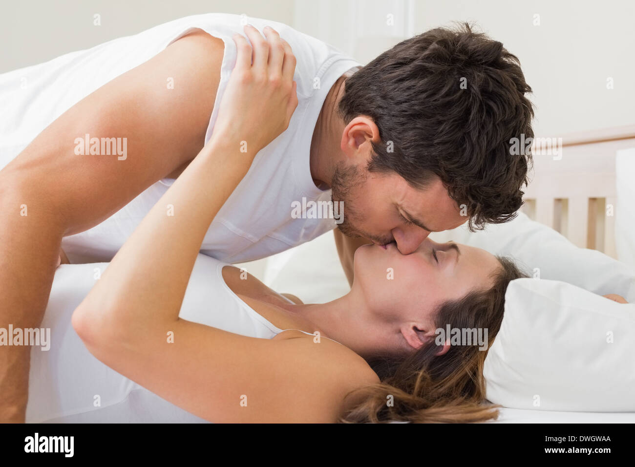 relaxed young couple kissing in bed